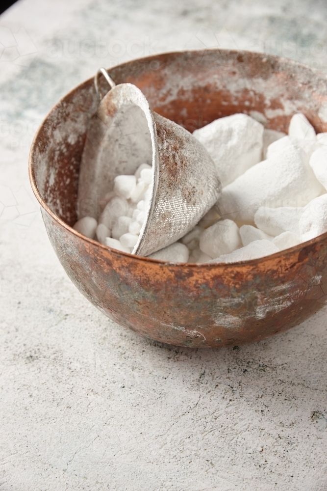 Image of Bowl of lumpy icing sugar with sieve - Austockphoto
