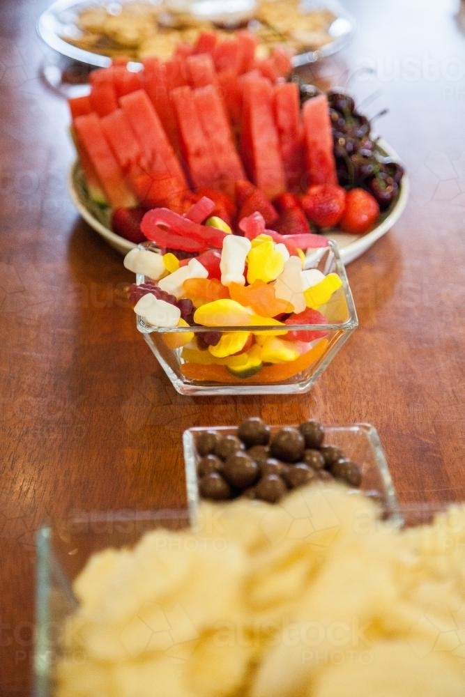 Image of Bowls of lollies, fruit, chips and chocolate ready for a party