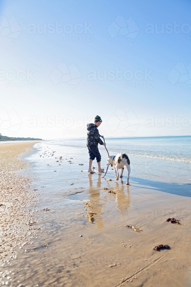 Boy and dog explore the remote coast of Queensland - Australian Stock Image