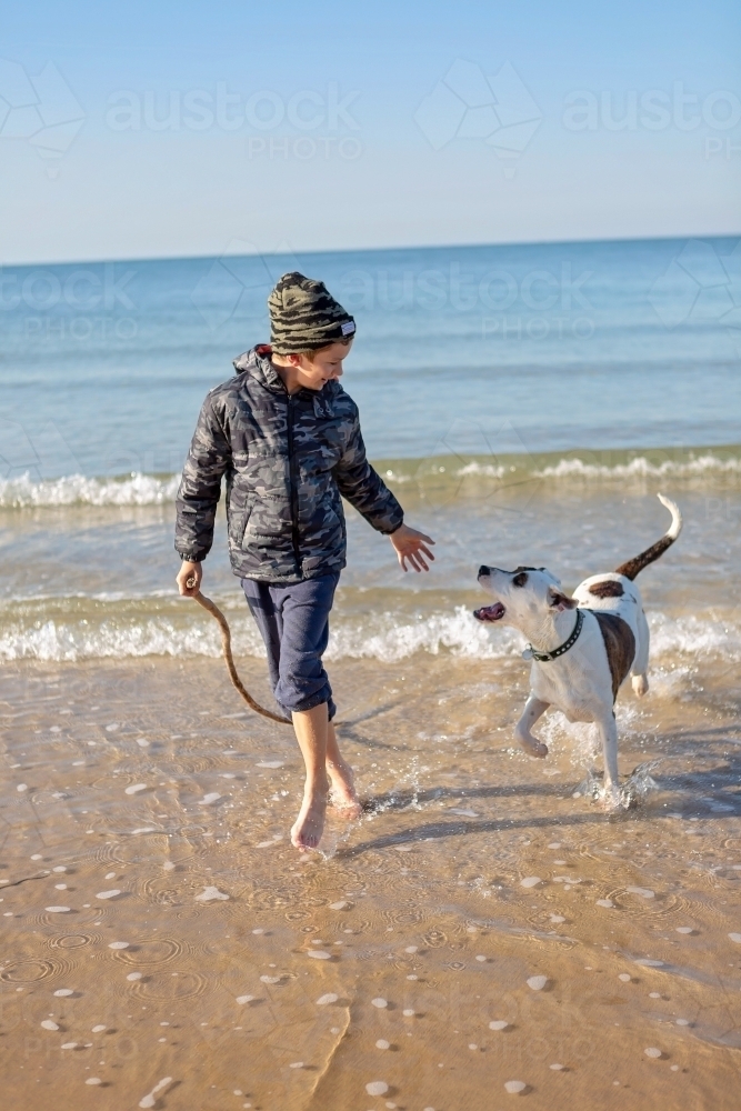 Boy and dog explore the remote coast of Queensland - Australian Stock Image