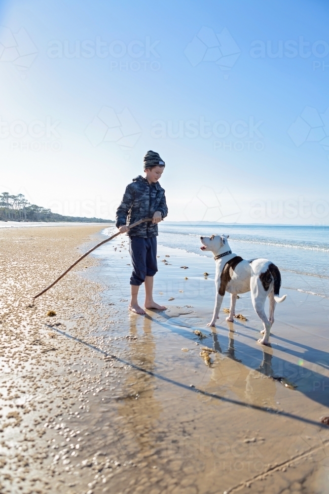 Boy and dog explore the remote coast of Queensland - Australian Stock Image
