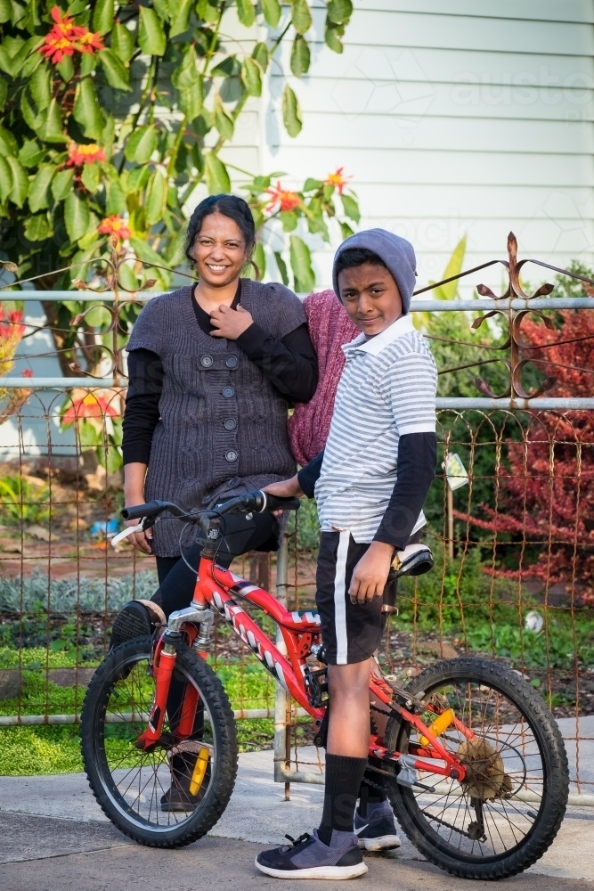 Boy and mum stand in front of their home - Australian Stock Image