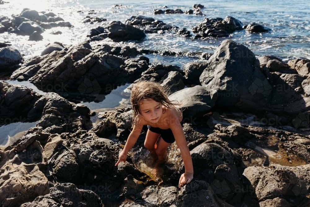 Boy exploring rock pools - Australian Stock Image