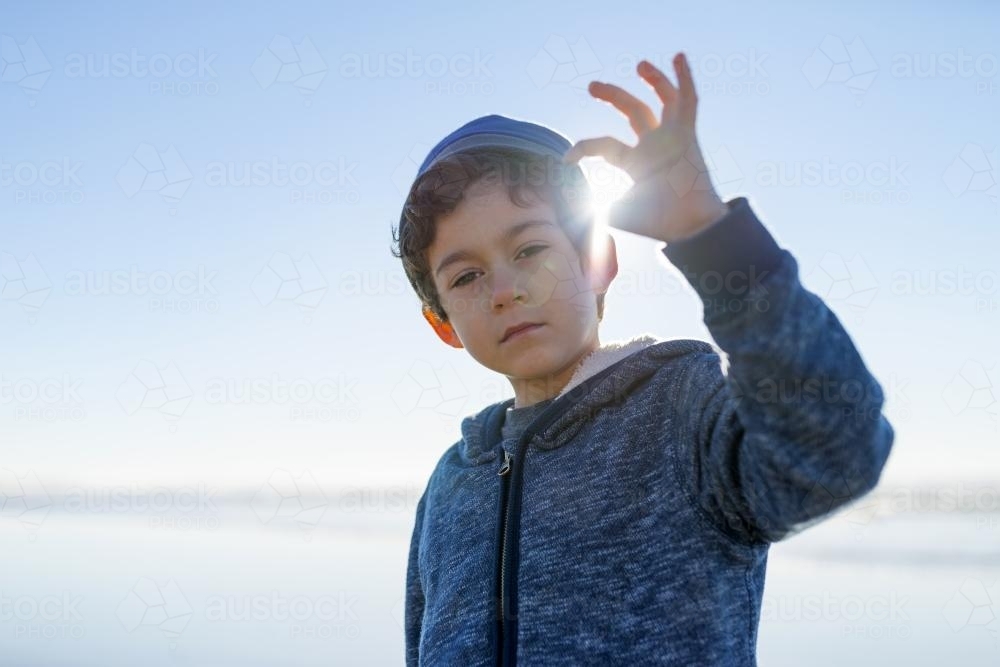 Boy holding light in his finger tips - Australian Stock Image