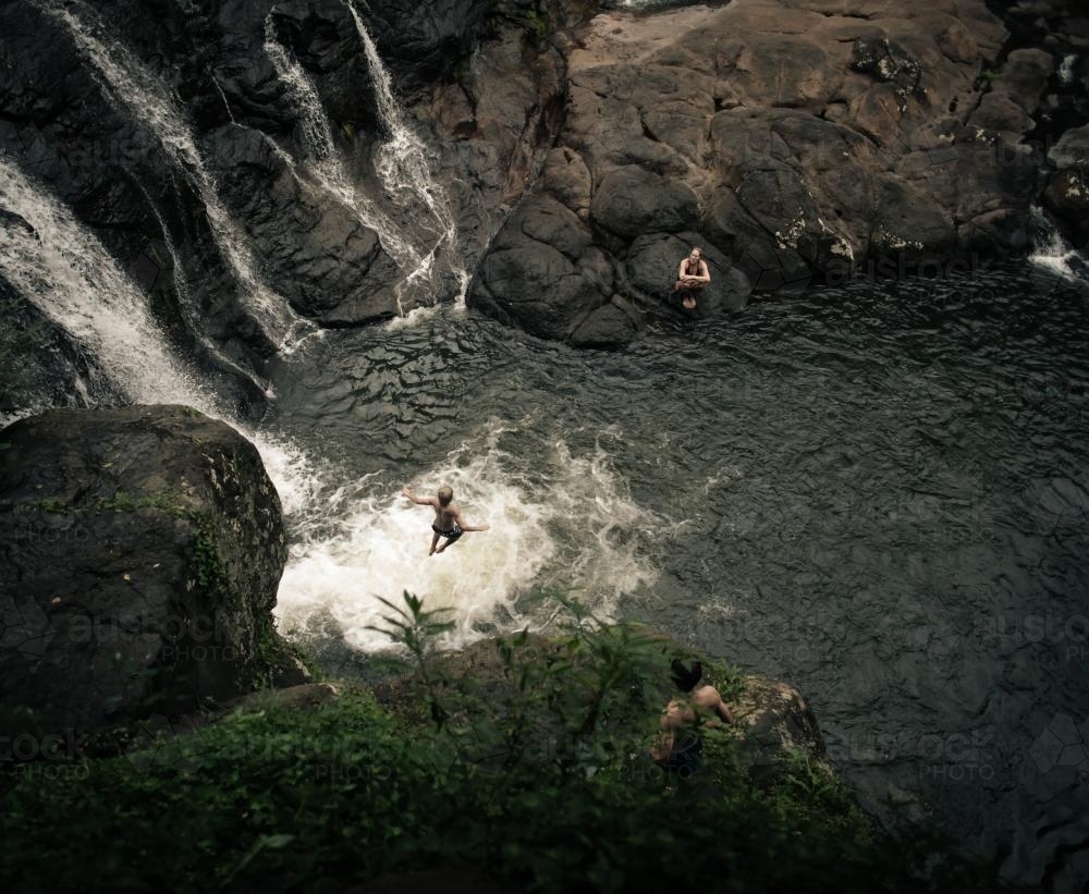 Boy jumping off a waterfall - Australian Stock Image