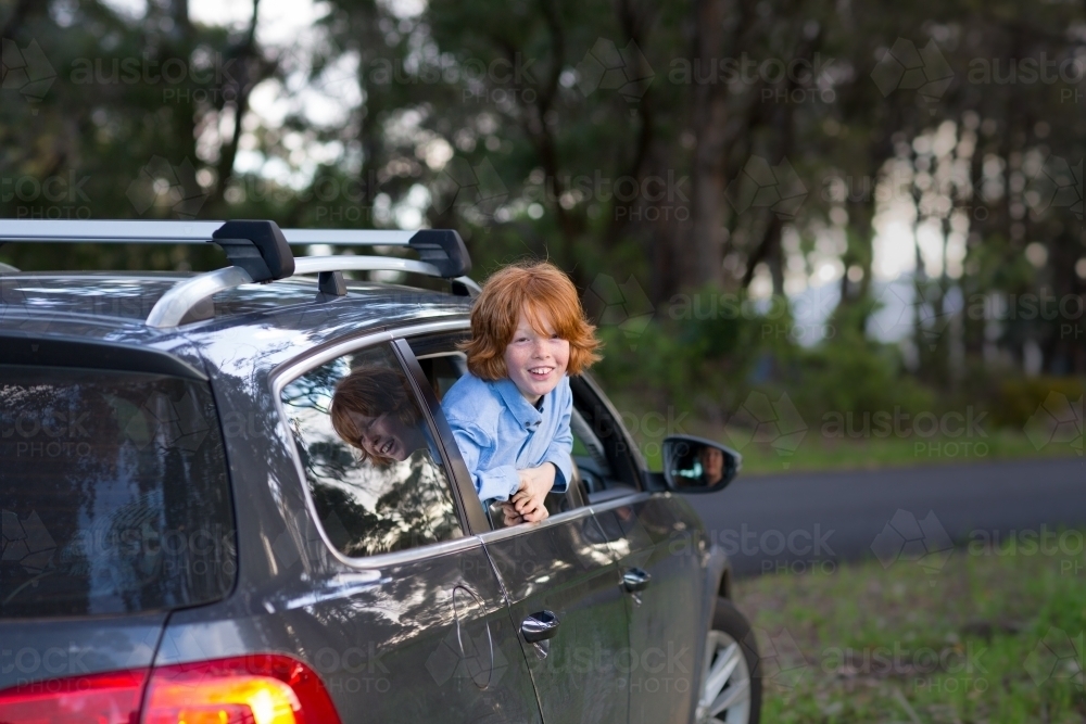 Boy leaning out of car window - Australian Stock Image