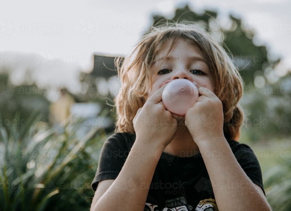 Boy learning to blow bubbles - Australian Stock Image