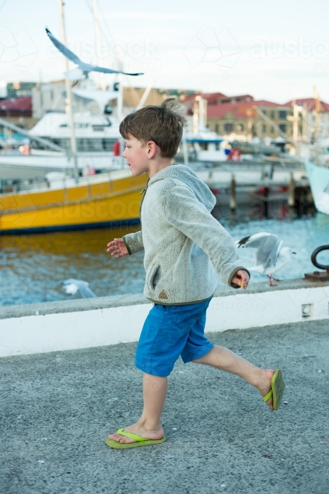 Boy on wharf marina with boats - Australian Stock Image