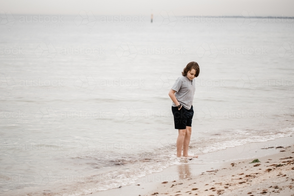 Boy playing at the beach - Australian Stock Image
