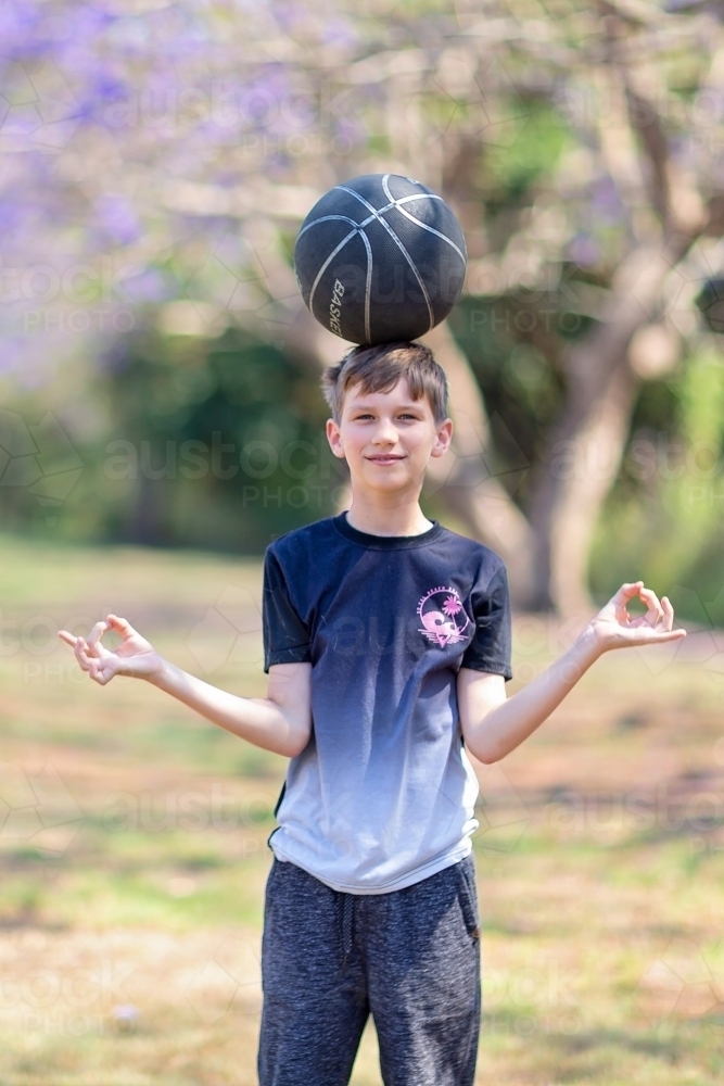 Boy playing outside with Jacaranda flowers - Australian Stock Image