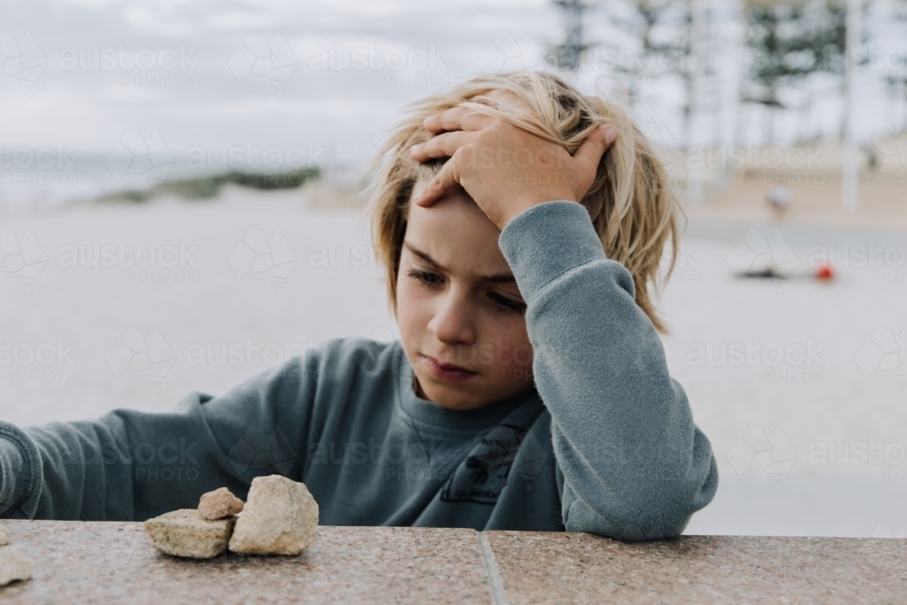 Boy playing with rocks - Australian Stock Image