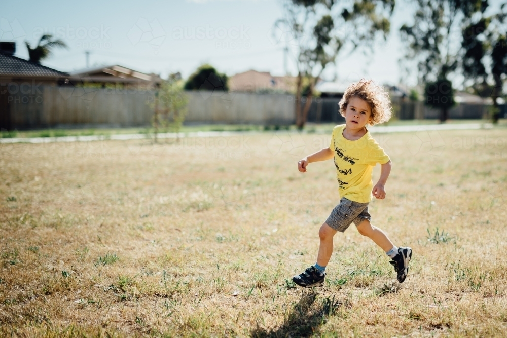 Boy running in a park - Australian Stock Image