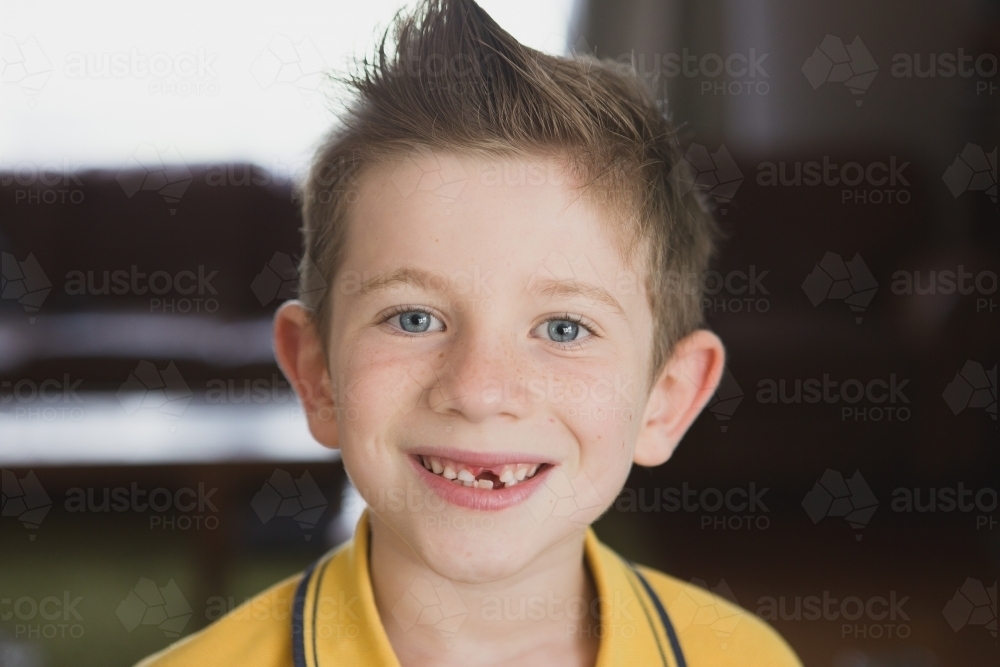 Boy smiling at camera with missing tooth - Australian Stock Image