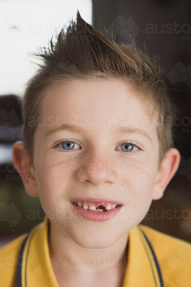 Boy smiling at camera with missing tooth - Australian Stock Image