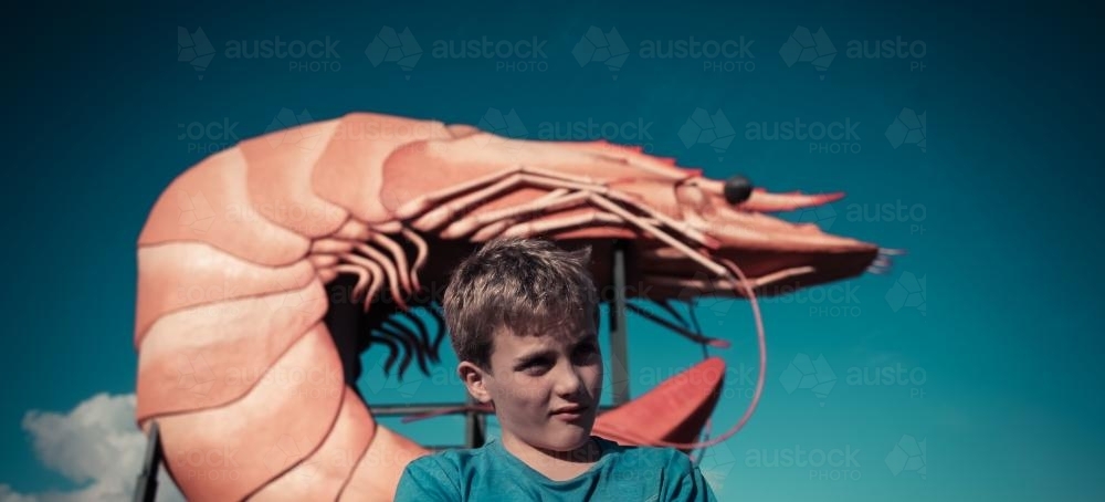 Boy standing in front of a big prawn - Australian Stock Image