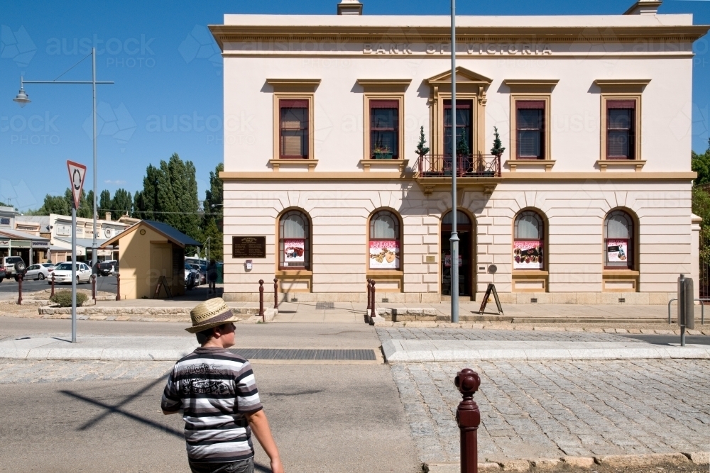 Boy stands outside of a historic building in regional Australia - Australian Stock Image