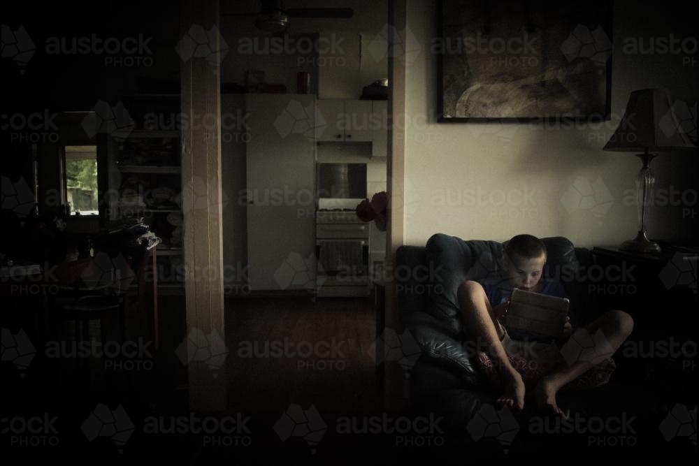 Boy staring into screen - Australian Stock Image