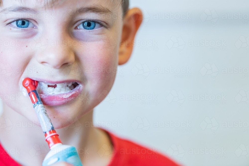 Boy using electric toothbrush - close up - Australian Stock Image