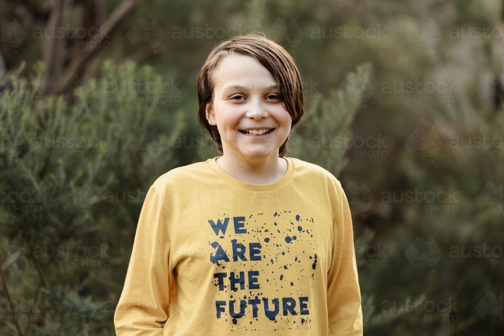 Boy wearing a generic yellow T-shirt that says we are the future - Australian Stock Image
