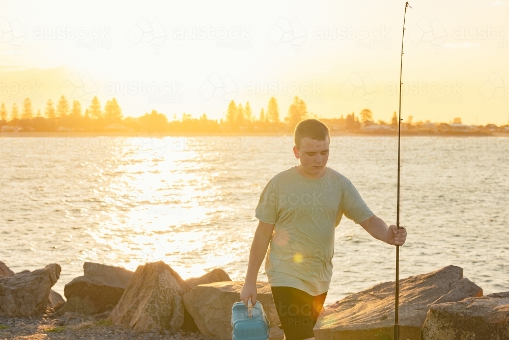 Image of Boy with fishing equipment on the Stockton breakwall in golden ...
