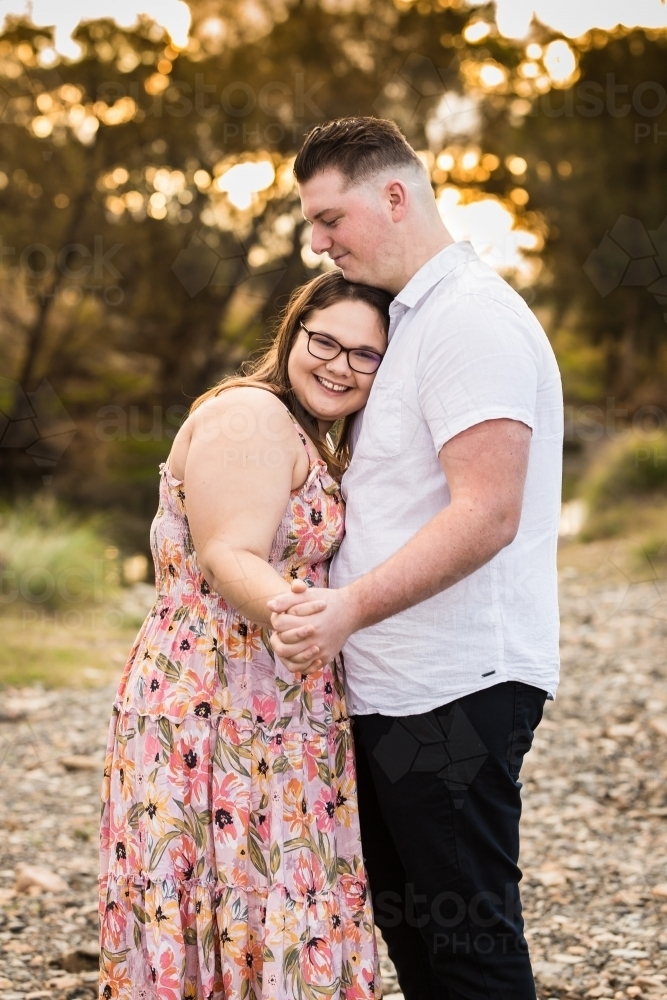 Boyfriend and girlfriend slow dancing in love smiling - Australian Stock Image