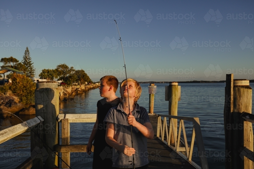 Boys fishing on jetty at Iluka, NSW Australia - Australian Stock Image