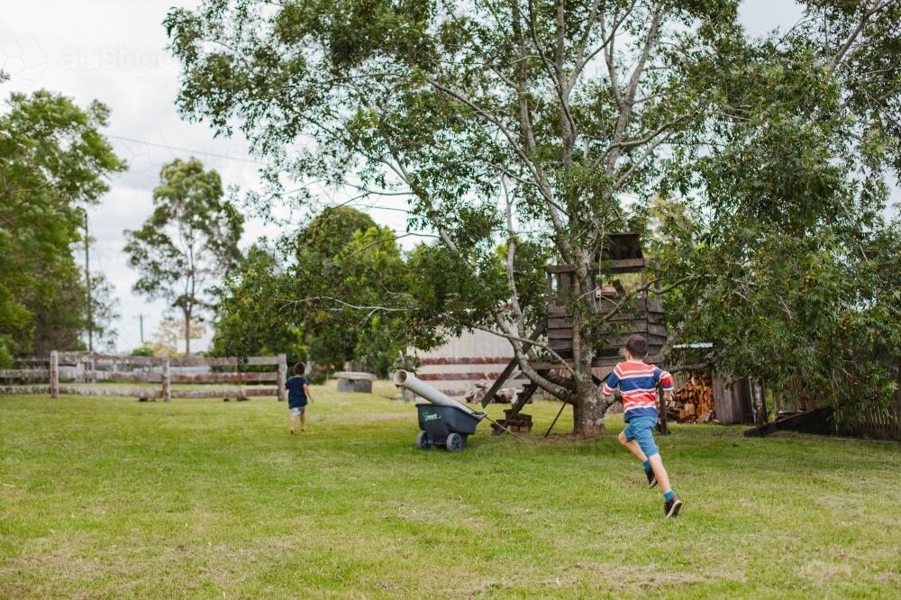 Boys running on farm - Australian Stock Image