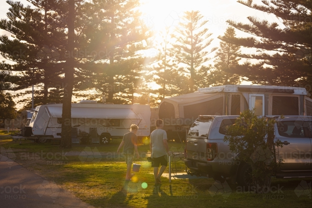 Boys walking through caravan park in golden afternoon light - Australian Stock Image
