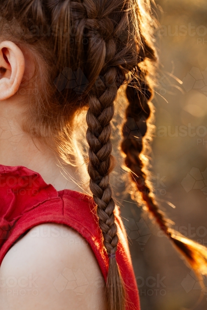 Braids in little girls hair in golden country light - Australian Stock Image