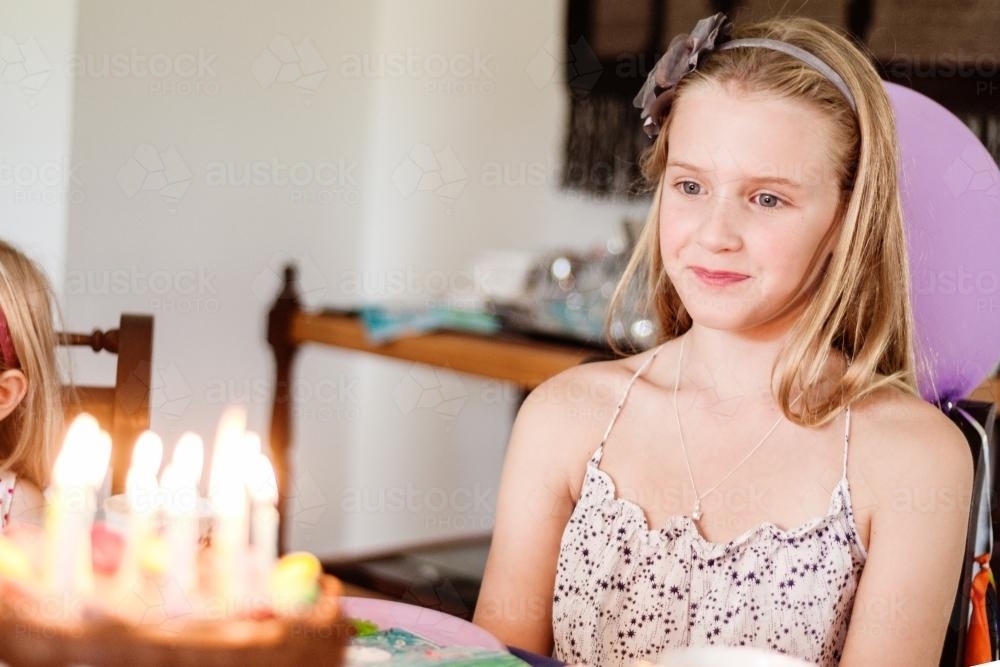 bratty tween looking at her birthday cake - Australian Stock Image