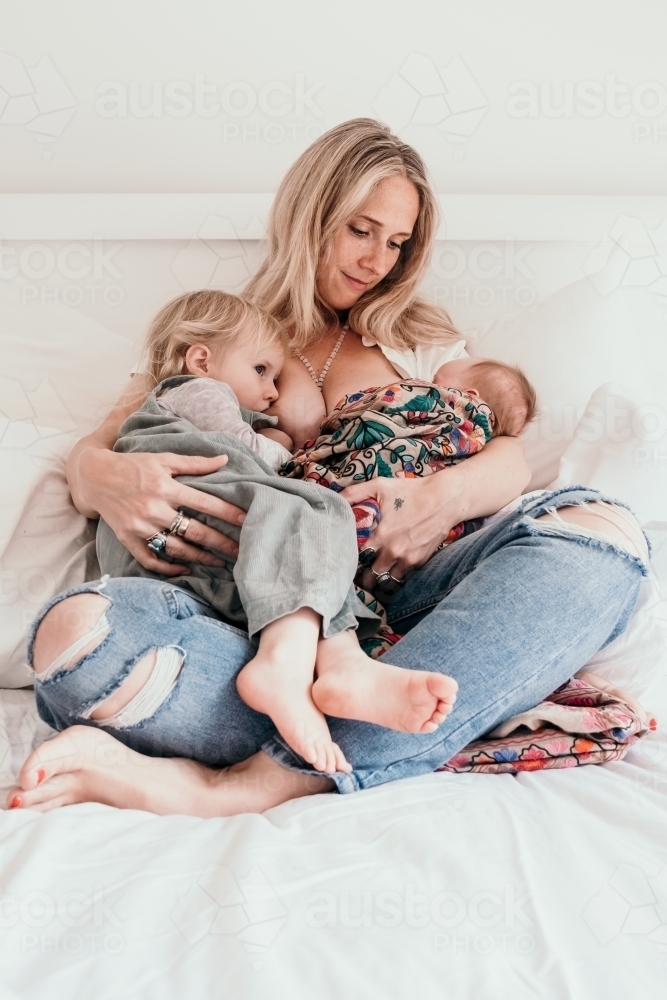 Breast feeding mother and her two children. - Australian Stock Image