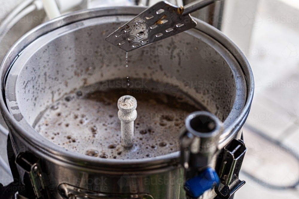 Brewing mash paddle removed from beer boiler - Australian Stock Image