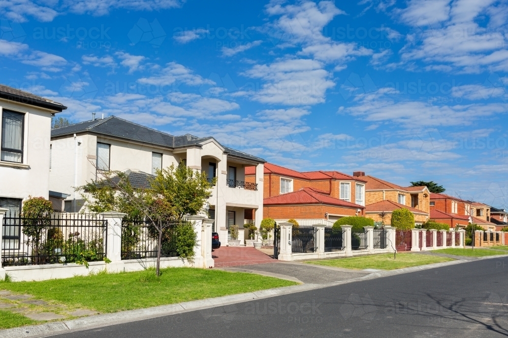 Brick houses along sunlit street in suburb of Melbourne Australia - Australian Stock Image