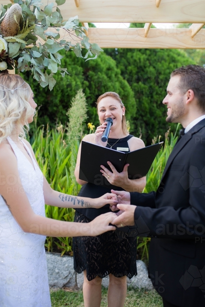 Bride and groom at wedding ceremony with celebrant - Australian Stock Image