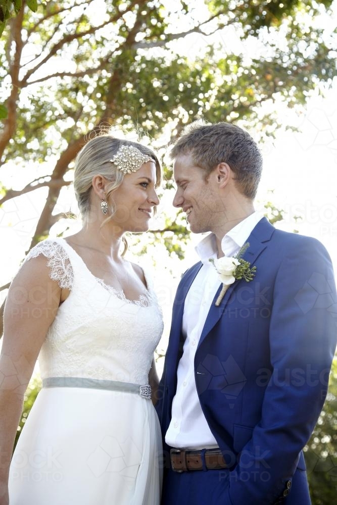 Bride and groom looking at each other in garden - Australian Stock Image