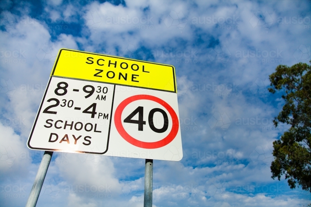 Bright 40 school zone sign against clouded sky - Australian Stock Image