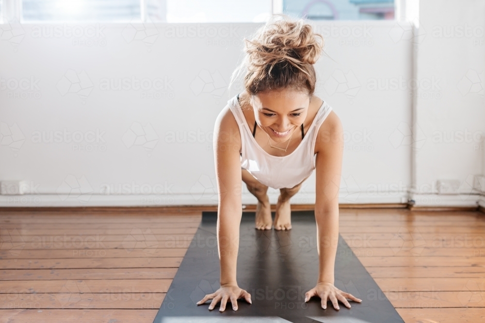 Bright pilates studio with girl doing a plank - Australian Stock Image