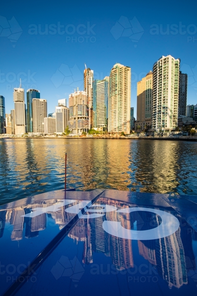 Brisbane city apartments reflected on the hull of a CityCat travelling on the Brisbane River - Australian Stock Image