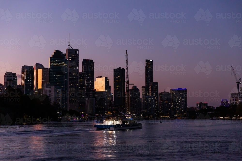 Brisbane city skyscrapers and ferry after sunset - Australian Stock Image