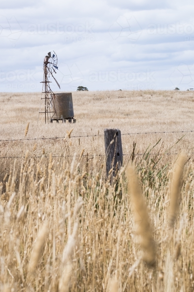 Broken windmill and old fence in the country - Australian Stock Image