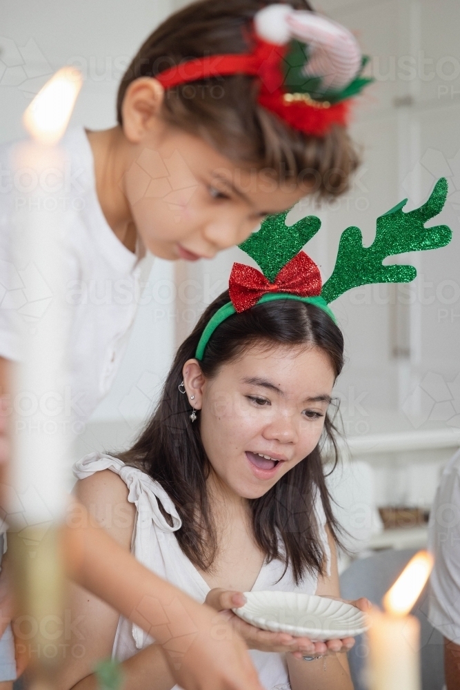 Brother and sister dishing up food onto plate - Australian Stock Image