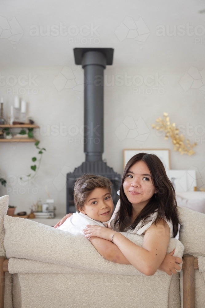 Brother and sister on couch at home together - Australian Stock Image