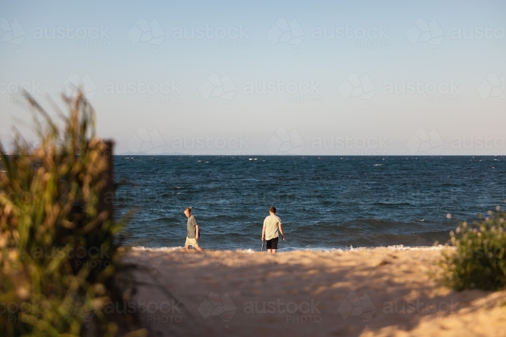 Brothers on the beach with sand pump. Teenage boys outdoors. - Australian Stock Image