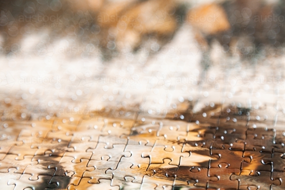 Brown and white puzzle pieces joined together - Australian Stock Image
