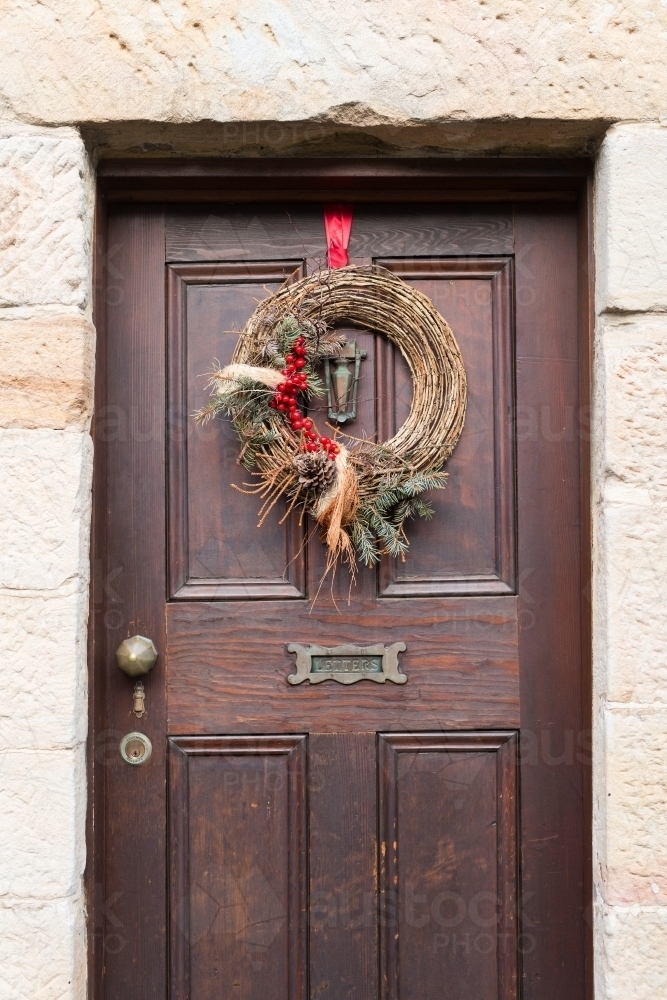 Brown timber front door with christmas wreath - Australian Stock Image