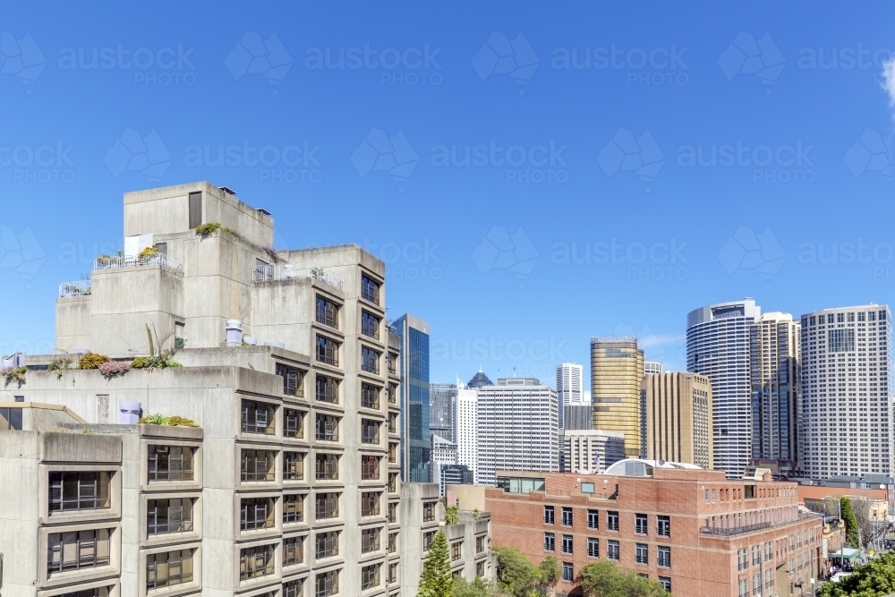 Brutalist apartments with city skyline behind - Australian Stock Image