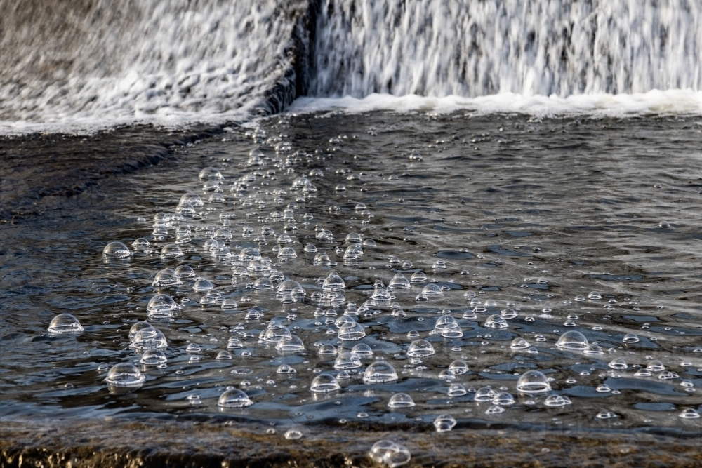 Bubbles in water spilling from dam wall - Australian Stock Image