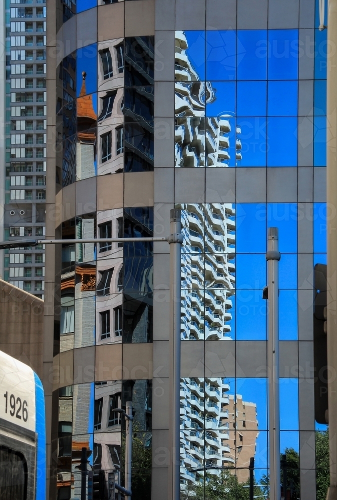 Buildings and blue sky reflected in high-rise windows in city street - Australian Stock Image