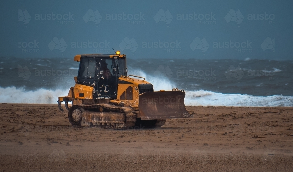 Bulldozer in operation crawling along the beach - Australian Stock Image