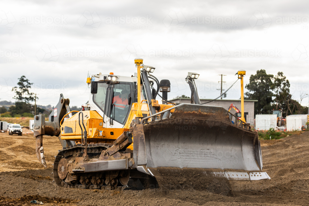 Bulldozer pushing dirt around construction worksite - Australian Stock Image